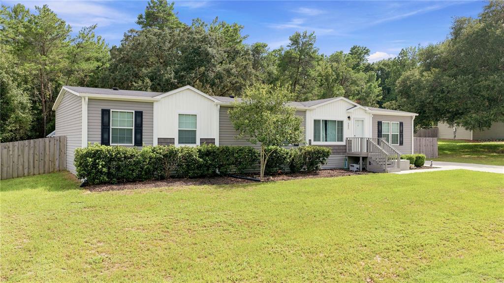 A single-story manufactured home with grey siding, white accents, and a small front porch — 122 SE 70TH CIRCLE, OCALA, FL