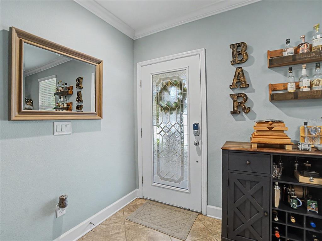 A blue front door with a wreath and a welcome sign sits on a porch — 16910 DORMAN ROAD, LITHIA, FL