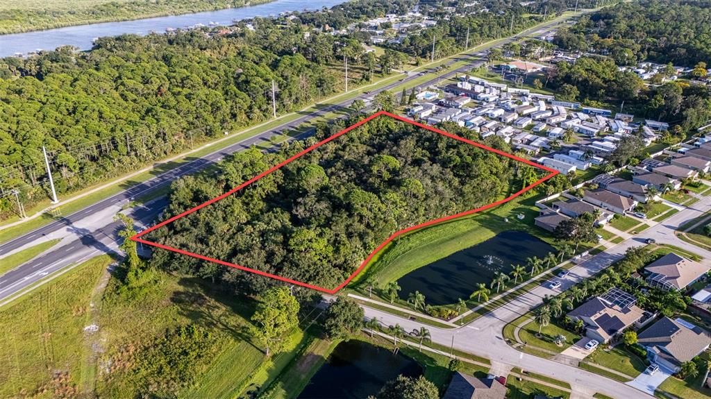 An aerial view shows a wooded, rectangular plot of land outlined in red near houses — 2370 S RIDGEWOOD AVENUE, EDGEWATER, FL
