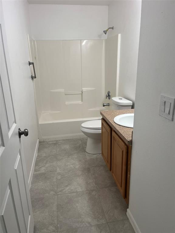 A bathroom features a beige tub-shower combo, a white toilet, and a wood vanity cabinet — 3422 NW 26TH AVENUE, OKEECHOBEE, FL