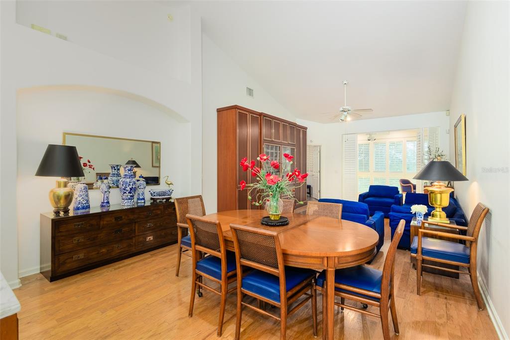 A dining room with a wooden table, blue chairs, and a large wooden storage cabinet — 334 ENCLAVE DRIVE UNIT 334, LAKELAND, FL