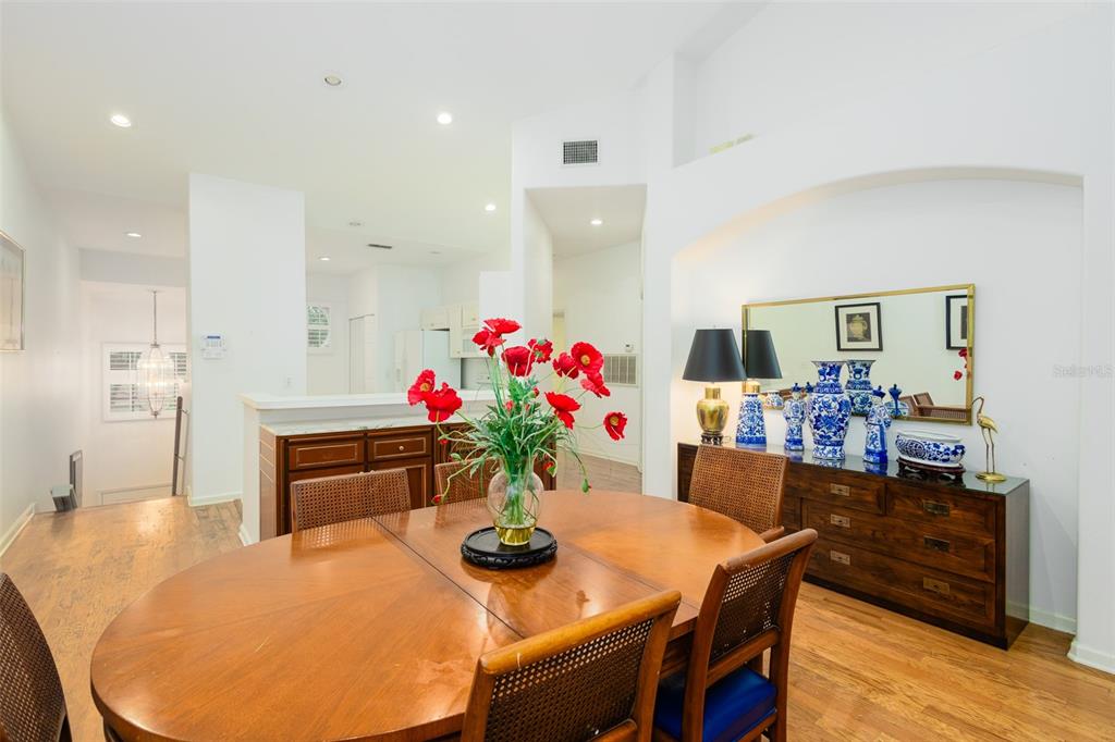 A dining room features a wooden table, cane-back chairs, and a sideboard with blue vases — 334 ENCLAVE DRIVE UNIT 334, LAKELAND, FL
