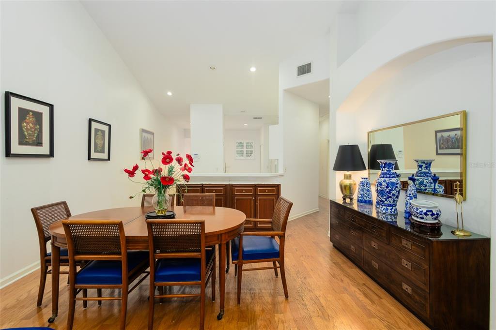 A dining room features a round wooden table, blue-cushioned chairs, and a long sideboard — 334 ENCLAVE DRIVE UNIT 334, LAKELAND, FL