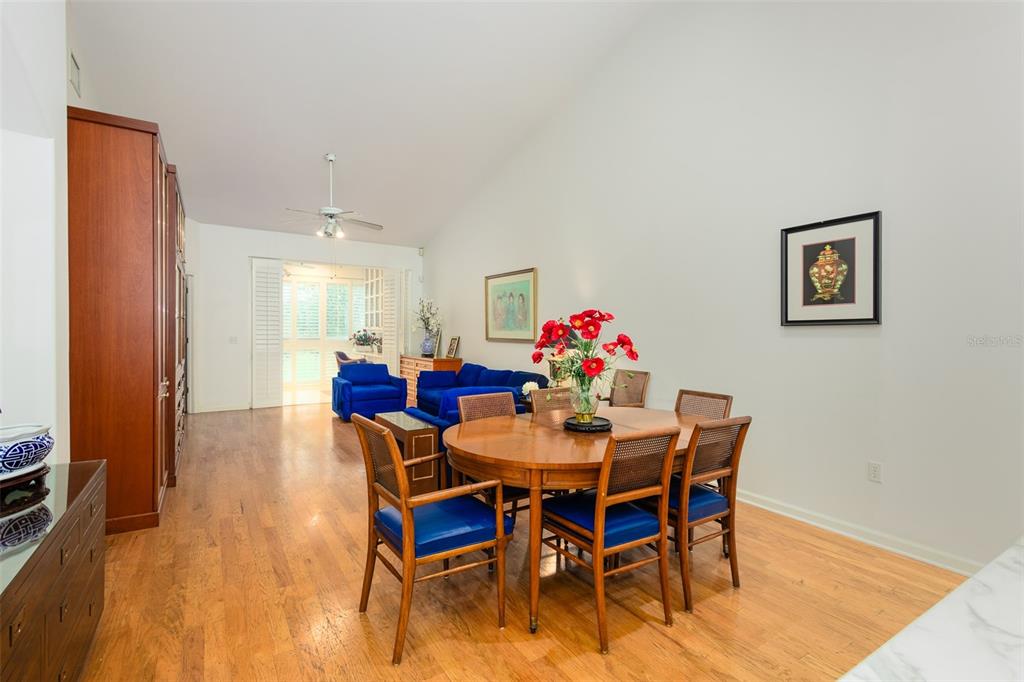 A dining area with a wooden table and chairs sits before a blue living room — 334 ENCLAVE DRIVE UNIT 334, LAKELAND, FL