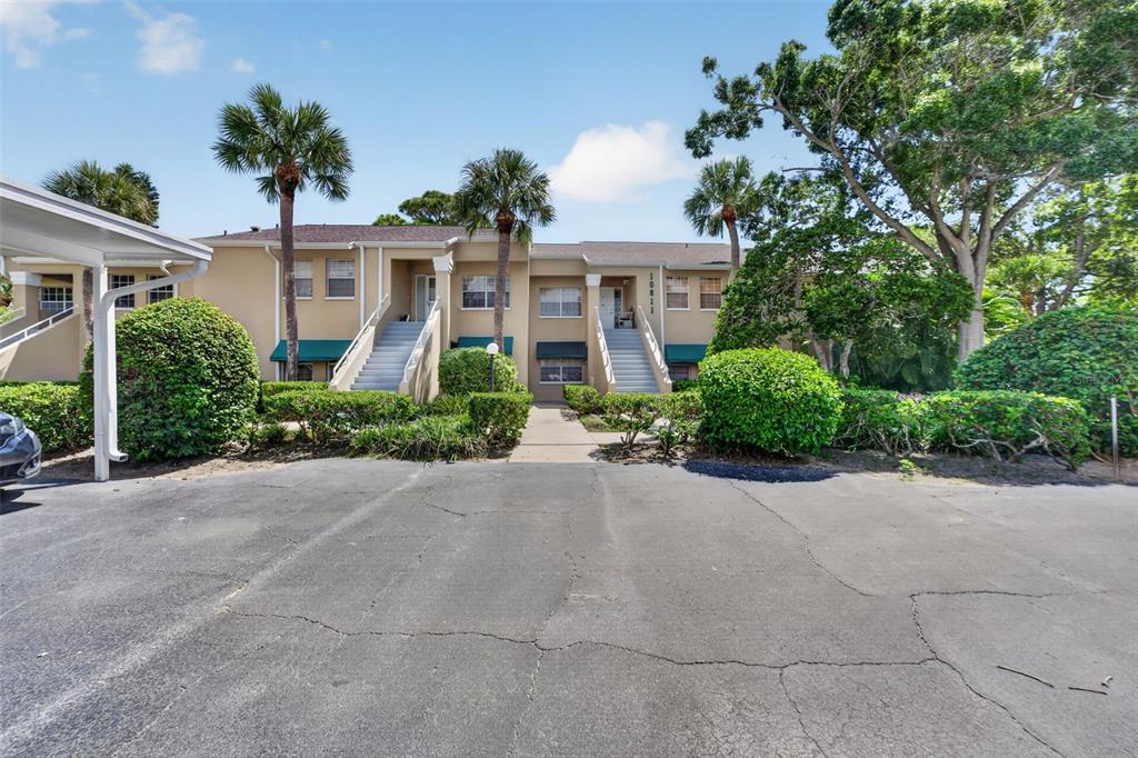 A two-story apartment building with stairs leading to upper units and a paved parking area — 10811 INDIAN HILLS COURT UNIT 37, SEMINOLE, FL