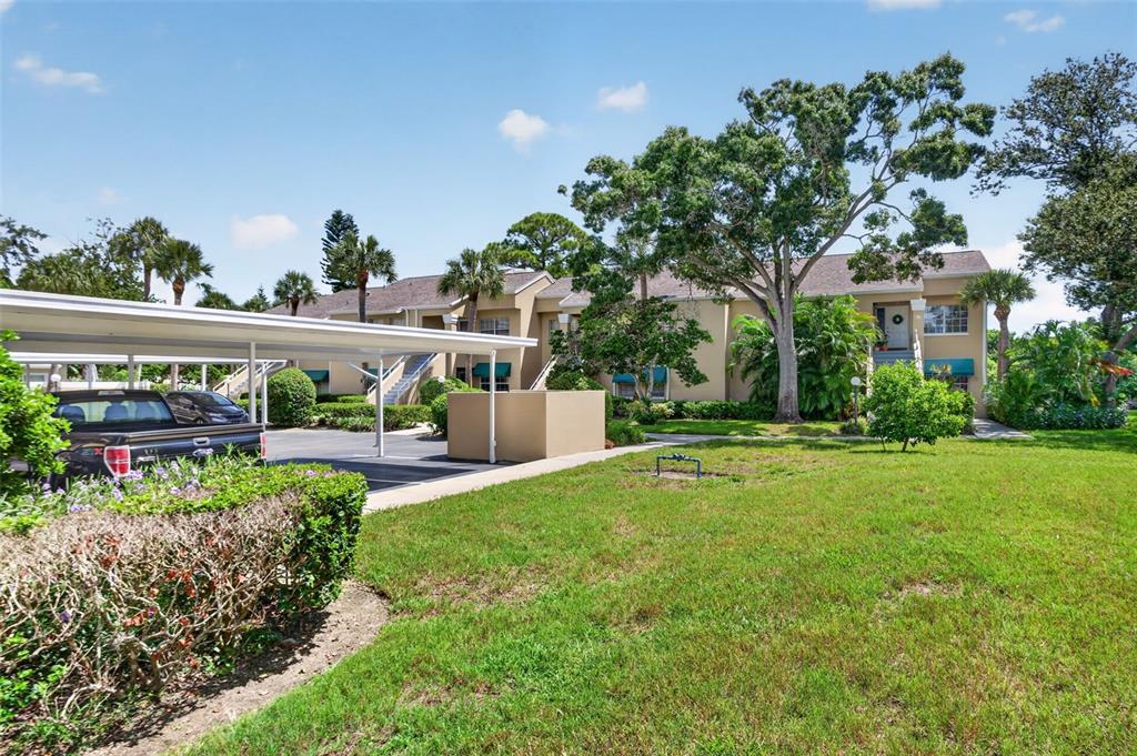 A multi-story apartment building with a covered parking area and a grassy lawn — 10811 INDIAN HILLS COURT UNIT 37, SEMINOLE, FL