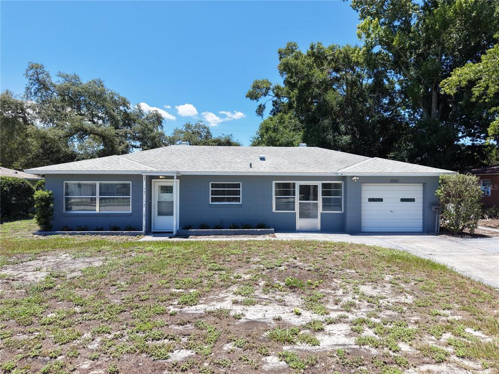 A single-story gray house with a white front door, garage, and a large front yard — 2980 WESTLAND ROAD, MOUNT DORA, FL