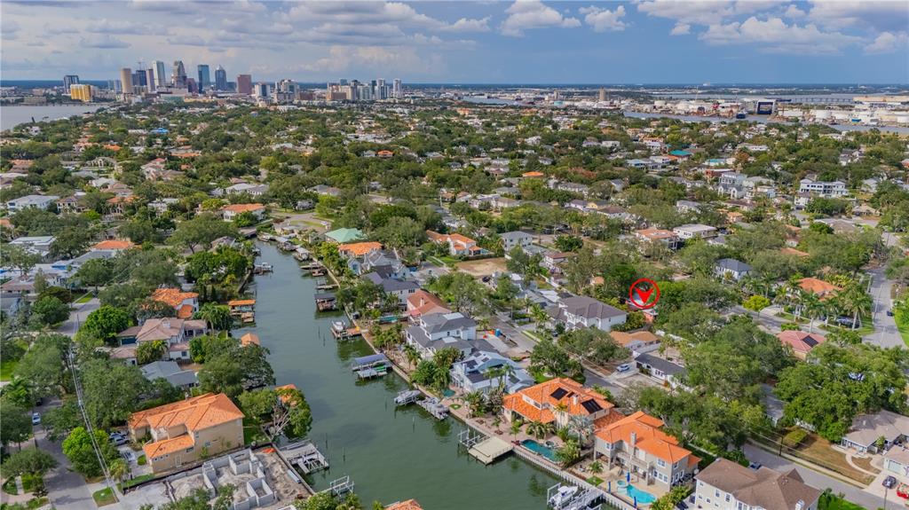An aerial view shows waterfront houses along a canal with a city skyline in distance — 504 W DAVIS BOULEVARD, TAMPA, FL