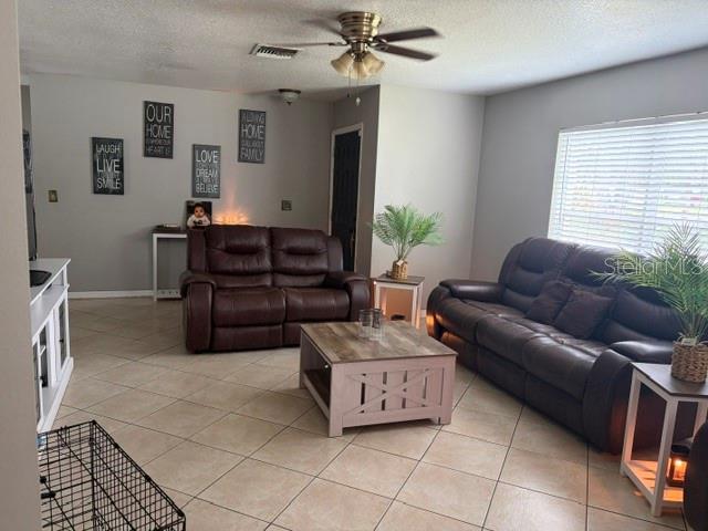 A living room features brown leather sofas, a wooden coffee table, and tile flooring — 914 NICHOLSON ST, CLEARWATER, FL