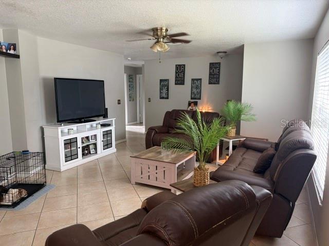 A living room features tile flooring, a white media console, and brown leather furniture — 914 NICHOLSON ST, CLEARWATER, FL