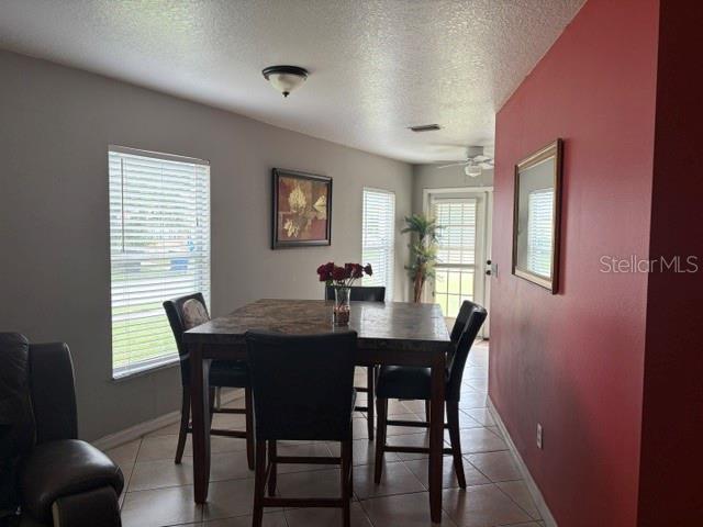 A dining area features a square table with four chairs, tile flooring, and a red wall — 914 NICHOLSON ST, CLEARWATER, FL