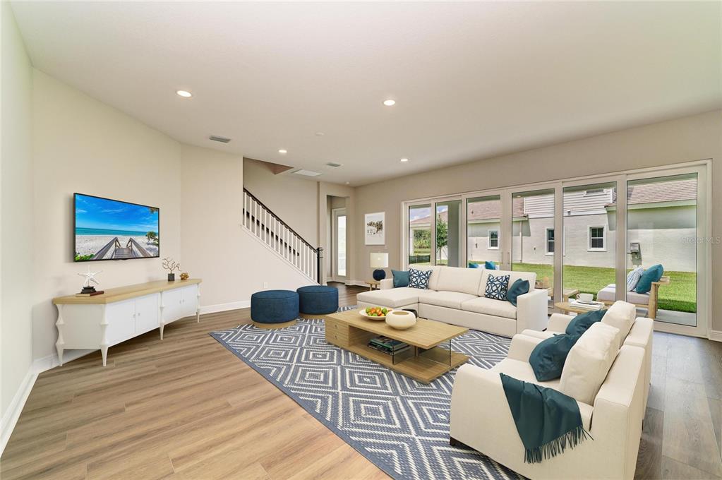 A living room features light wood floors, a white sectional sofa, and large sliding glass doors — 10245 CROSS RIVER TRAIL, PARRISH, FL