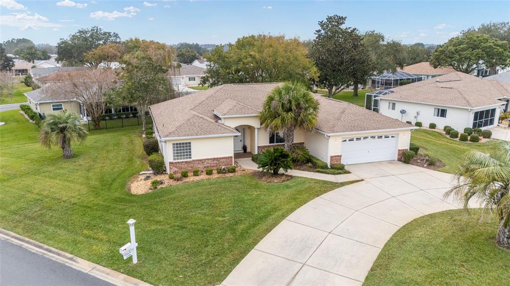 A single-story house with light yellow siding, a brick base, and a two-car garage — 13766 SE 89TH AVENUE, SUMMERFIELD, FL
