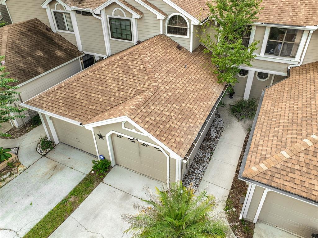 A tan two-story townhouse with a garage, a small front yard, and a large tree — 635 NORTHBRIDGE DRIVE, ALTAMONTE SPRINGS, FL