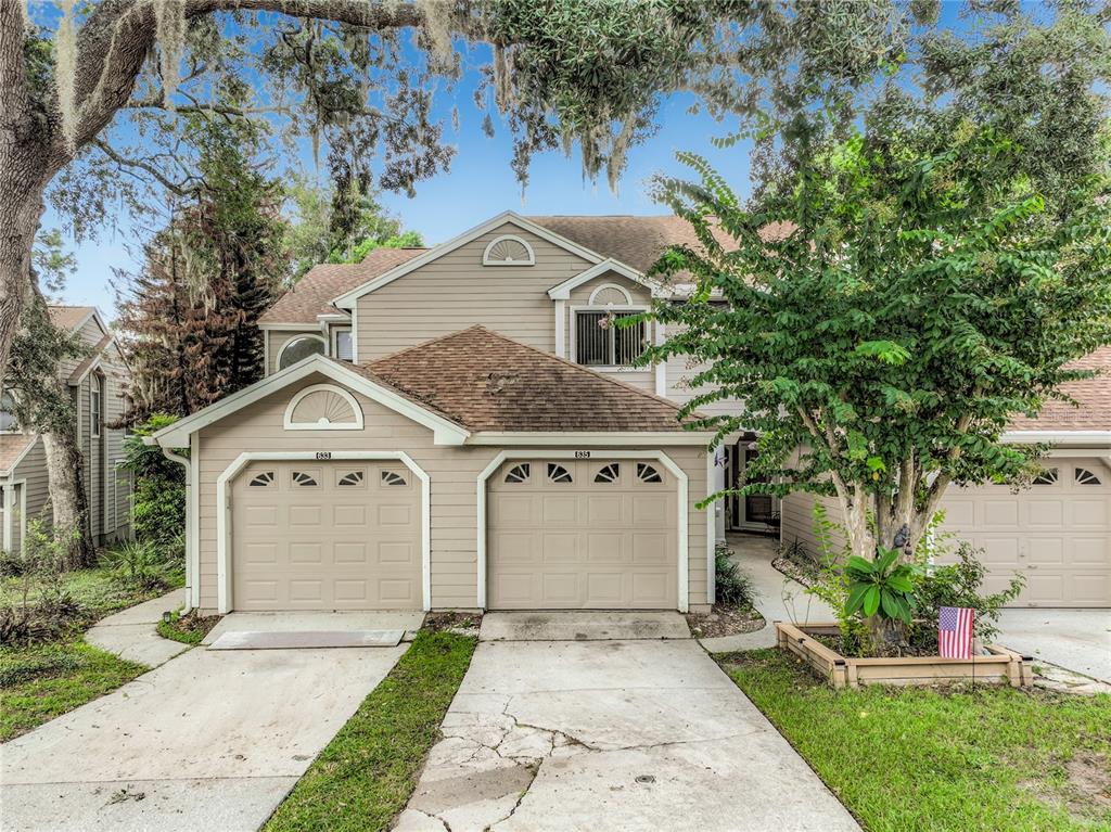 The exterior of a house features a tan garage door, a concrete walkway, and beige siding — 635 NORTHBRIDGE DRIVE, ALTAMONTE SPRINGS, FL