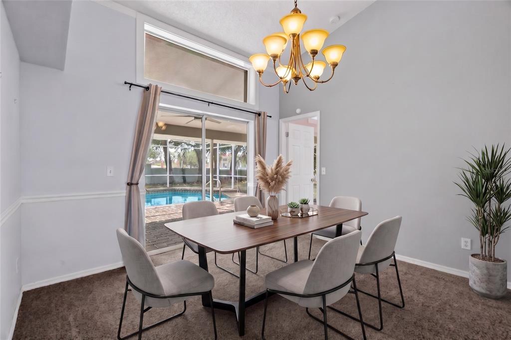 A dining area features a round table, four chairs, a chandelier, and sliding glass doors — 1174 MUSCOVY DRIVE, SPRING HILL, FL