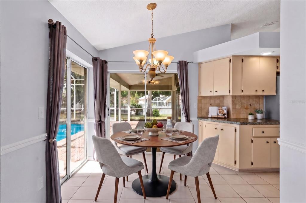 A living room features a stone fireplace, a large mirror, a ceiling fan, and hardwood floors — 1174 MUSCOVY DRIVE, SPRING HILL, FL