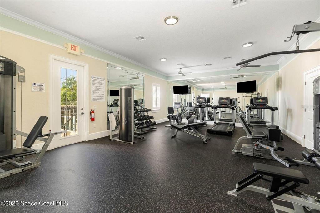 A fitness center features exercise equipment, mirrored walls, and black rubber flooring — 1800 KOLE PLACE, MELBOURNE, FL