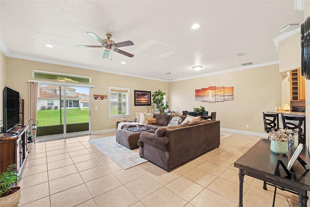 A spacious living room with tile floors, a large sectional sofa, and sliding glass doors — 1800 KOLE PLACE, MELBOURNE, FL