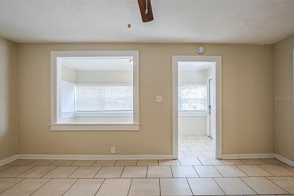 A room with beige walls, tiled floors, a large window opening, and a doorway — 2011 10TH STREET S, ST PETERSBURG, FL