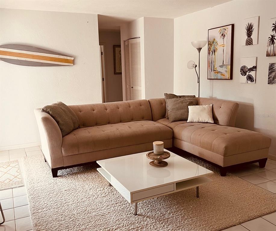 A living room features a beige sectional sofa, a white coffee table, and wall art — 2908 CAPTIVA DRIVE, SARASOTA, FL
