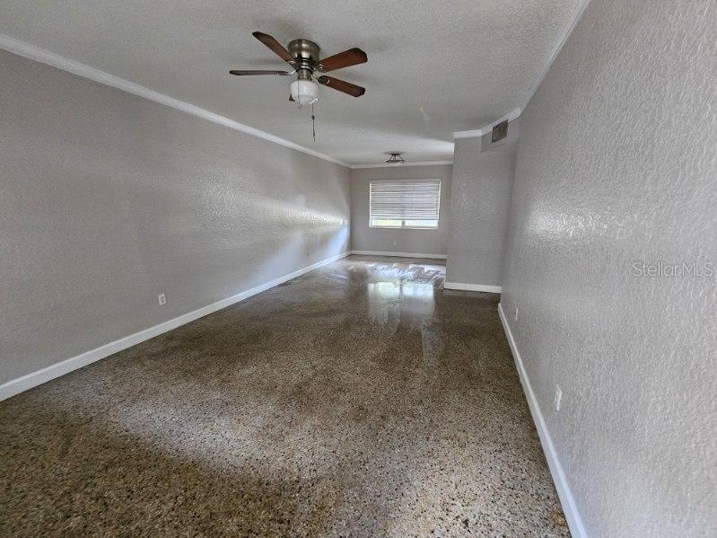 An empty room with light gray walls, a ceiling fan, and polished concrete flooring — 212 S CHURCH AVENUE UNIT 107, TAMPA, FL