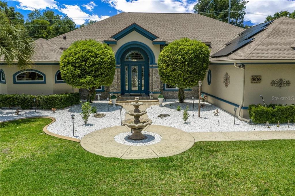 A single-story house with a large lawn, a central fountain, and palm trees — 3970 SE 39TH CIRCLE, OCALA, FL