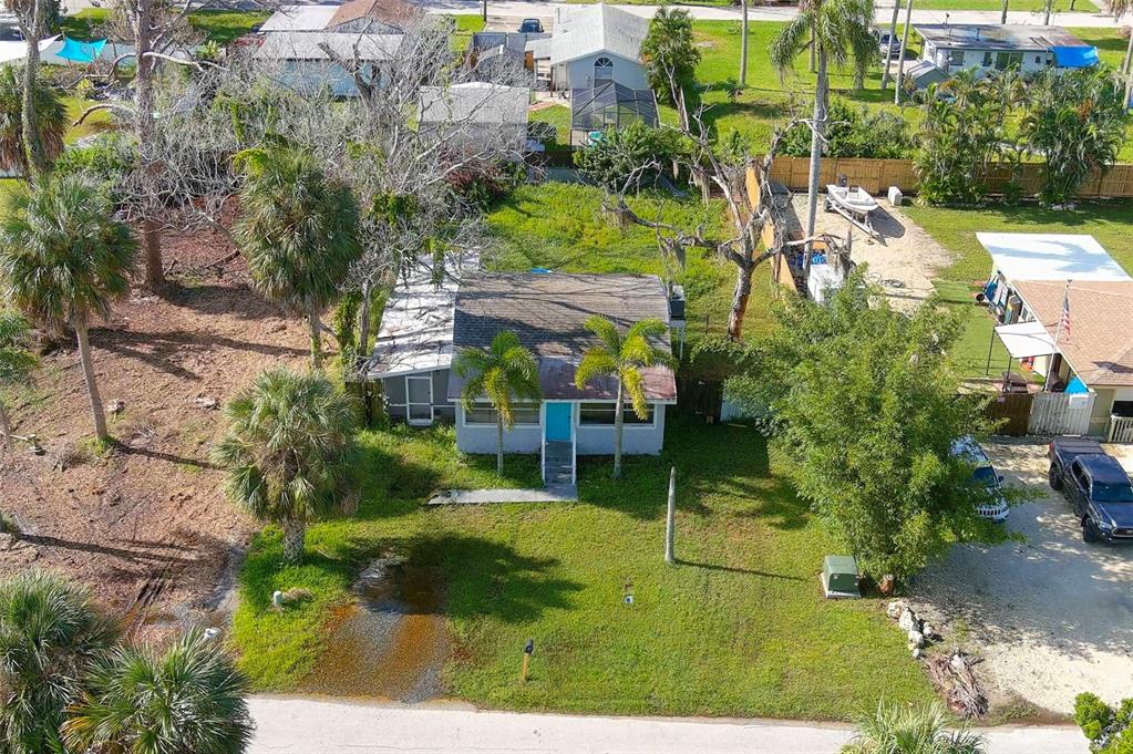 An aerial view shows a single-story house with a blue door and a grassy yard — 5200 MALLETT DRIVE, PORT RICHEY, FL