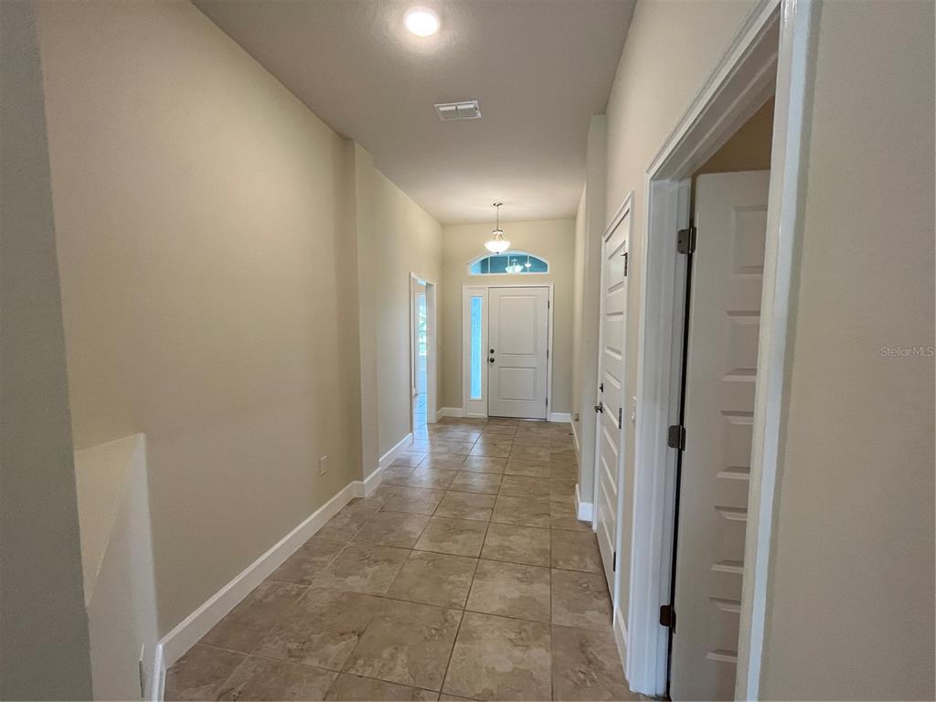A tiled hallway leads to a white front door with a transom window — 136 KRENSON BAY LOOP, WINTER HAVEN, FL