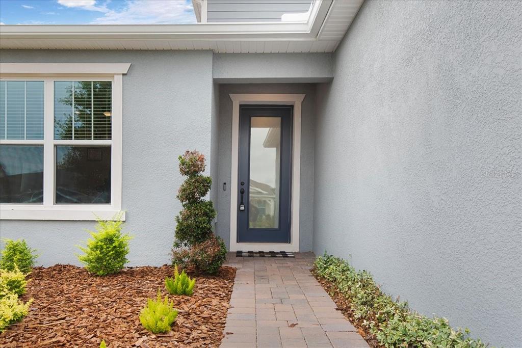 A blue, single-story suburban house features a front lawn, a walkway, and white-trimmed windows — 15363 WILLOW RIDGE DRIVE, MONTVERDE, FL