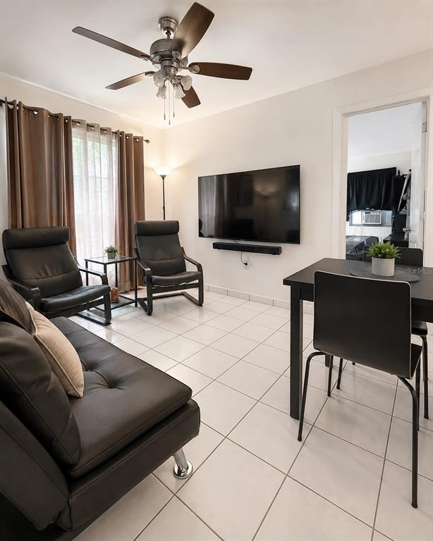 A living and dining area features white tile floors, a ceiling fan, and black furniture — 955 79TH TERRACE, MIAMI BEACH, FL
