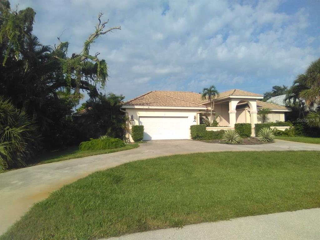 A single-story house with a beige exterior, a tiled roof, and a two-car garage — 2 ARLINGTON DRIVE, PLACIDA, FL
