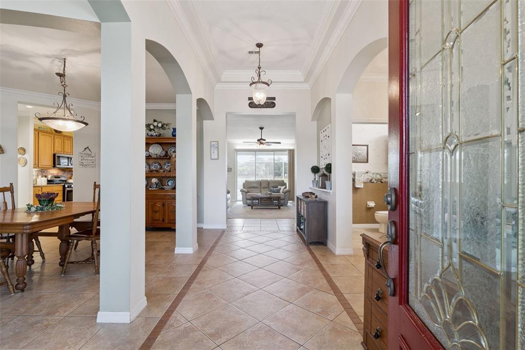 A view from an entryway looking through a tiled hallway toward a living room — 106 OAK HAVEN CIRCLE, DELAND, FL