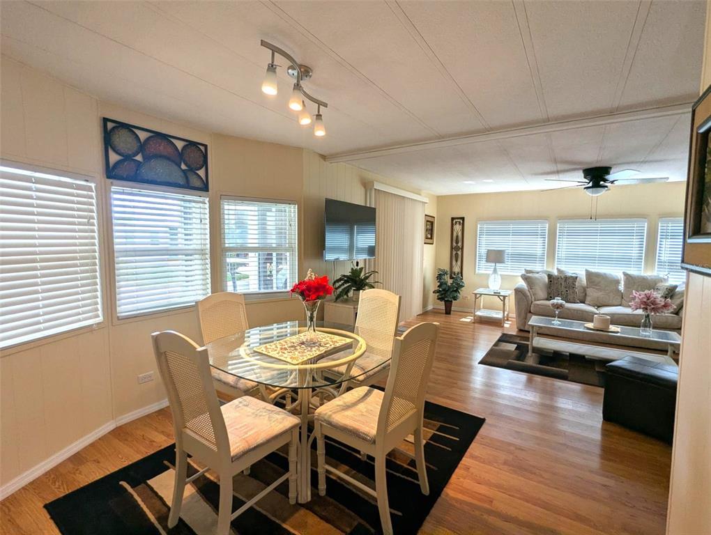A dining area with a glass table and chairs opens into a living room — 2100 KINGS HIGHWAY UNIT 137, PORT CHARLOTTE, FL