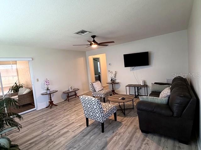 A modern kitchen features white cabinetry, stainless steel appliances, and light-colored tile flooring — 1629 WILLOW RUN, SEBRING, FL