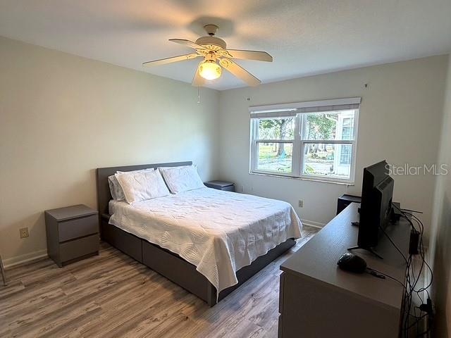A living room features light wood-look flooring, a dark sofa, and a patterned accent chair — 1629 WILLOW RUN, SEBRING, FL