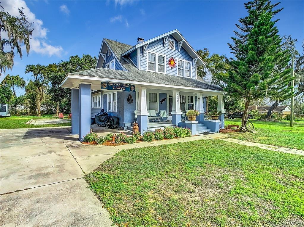 A light blue two-story house with a covered front porch and a concrete driveway — 510 TIGHE AVENUE, SEFFNER, FL