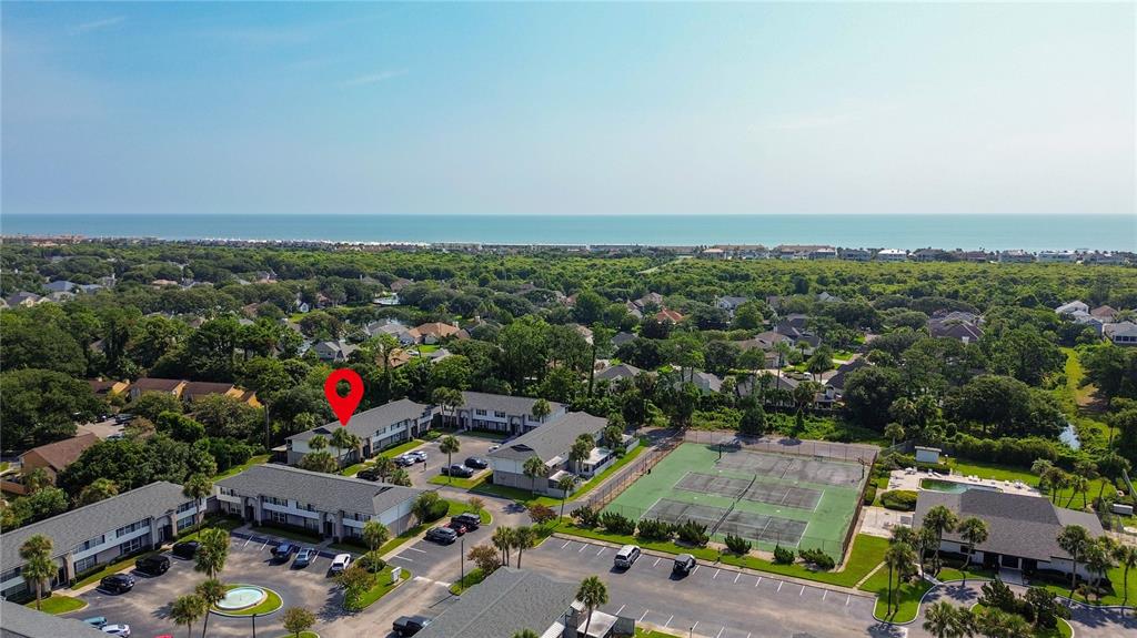 An aerial view shows a multi-building apartment complex with tennis courts and a parking lot — 695 A1A N UNIT 50, PONTE VEDRA BEACH, FL