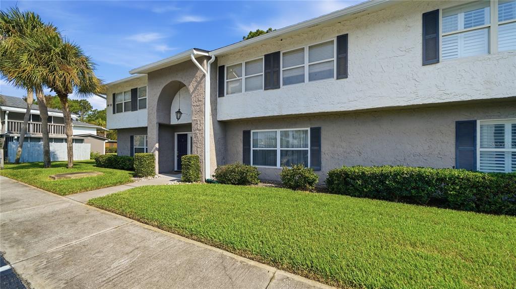 A two-story building with a stucco exterior, arched entryway, and a manicured front lawn — 695 A1A N UNIT 50, PONTE VEDRA BEACH, FL