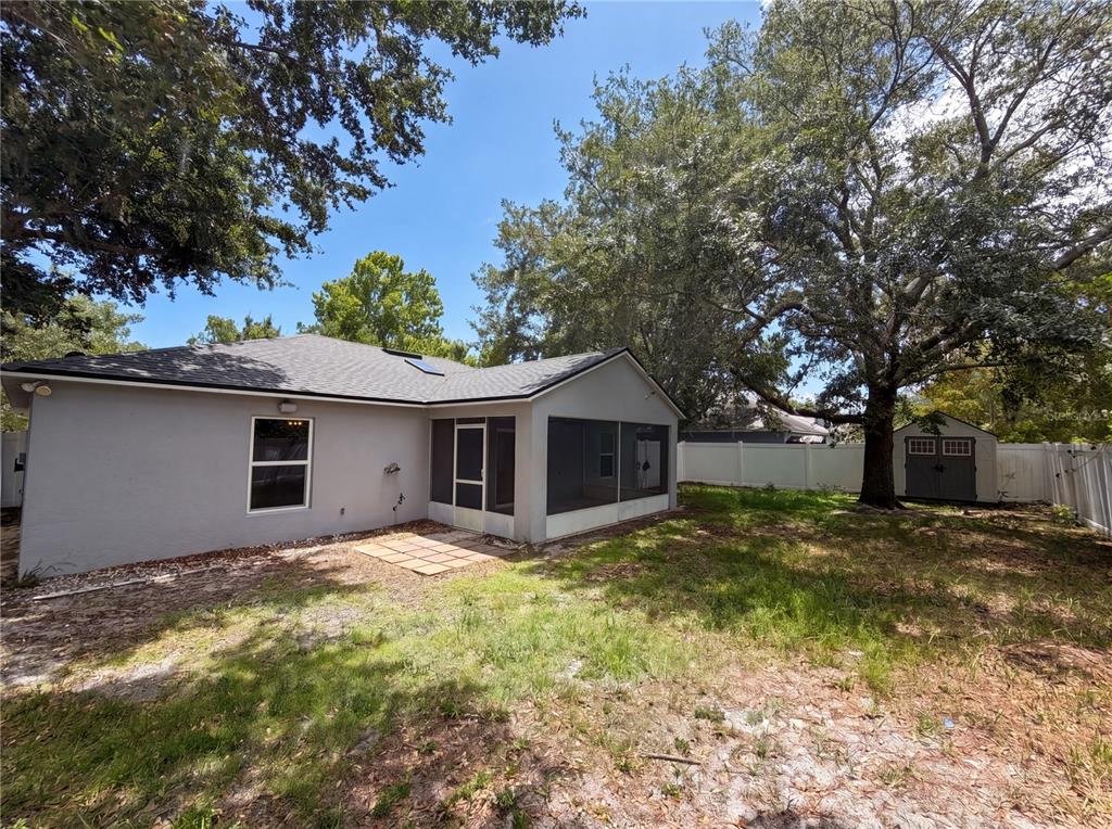 A gray house with a screened-in porch and a small shed in the backyard — 1360 WILDBERRY LANE, DELTONA, FL