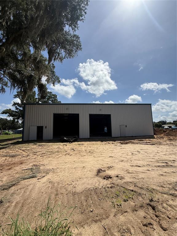 An expansive, empty warehouse interior features a concrete floor, metal walls, and exposed steel beams — 12142 SE COUNTY 484 HIGHWAY, BELLEVIEW, FL
