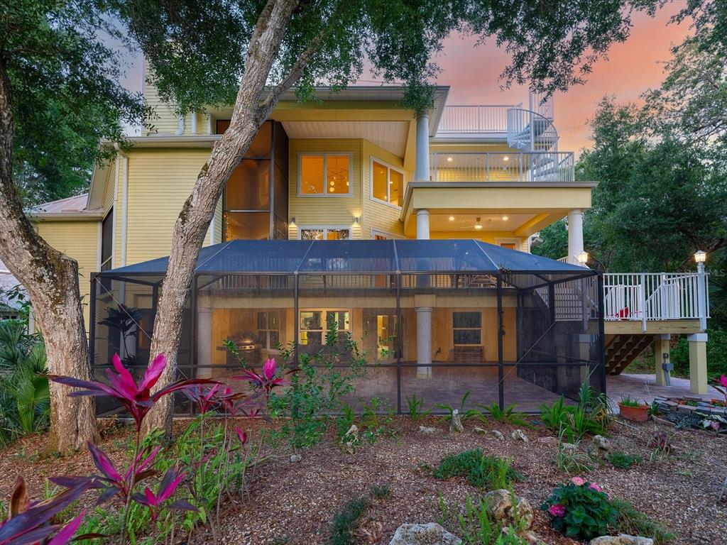 A yellow multi-story house features a screened-in patio, multiple balconies, and a spiral staircase — 110 OCEAN WAY DRIVE, PONCE INLET, FL