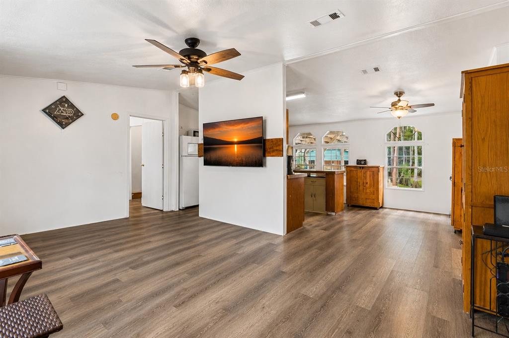 A single-story manufactured home with a paved driveway sits on a grassy lot near trees — 17808 DOGWOOD DRIVE, LUTZ, FL