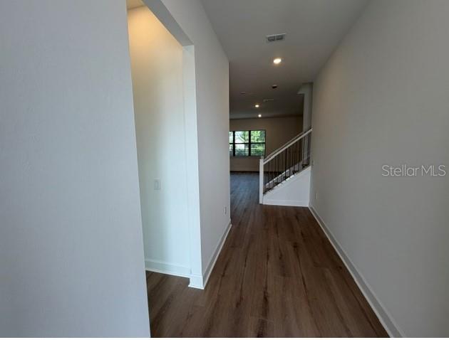 A modern living room features a sectional sofa, light wood floors, and an open kitchen — 7444 SUMMER COURT, SARASOTA, FL