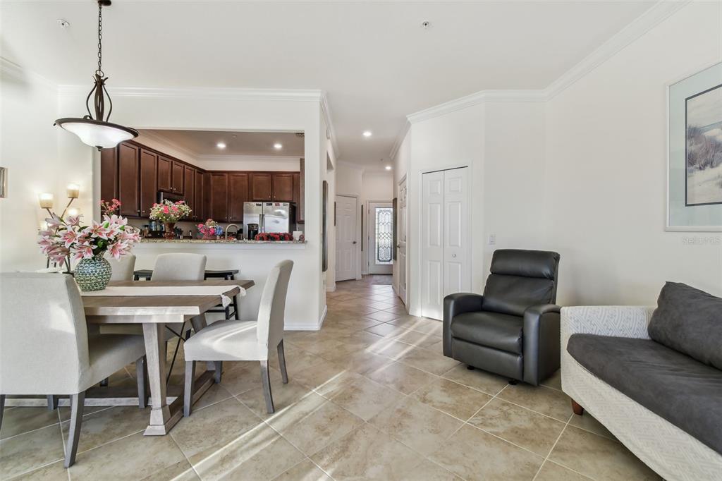 A dining area with a kitchen pass-through, tile flooring, and a nearby seating area — 20252 LAGENTE CIRCLE, VENICE, FL