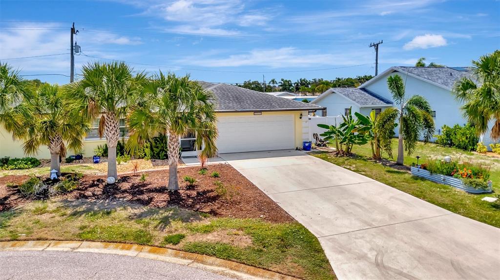 A single-story house with a white garage door, palm trees, and a concrete driveway — 5729 AUGUSTA CIRCLE, SARASOTA, FL