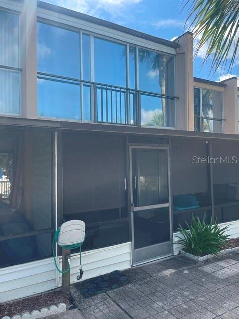 A two-story building features a screened-in ground floor patio and a large upper-level window — 5500 OCEAN SHORE BOULEVARD UNIT UT42, ORMOND BEACH, FL