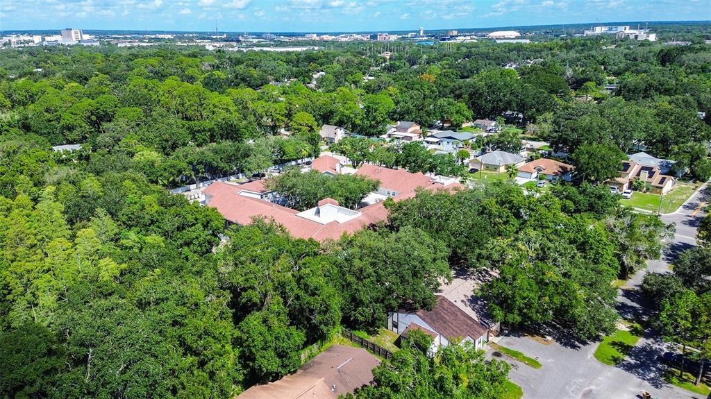 An aerial view shows a large residential complex surrounded by dense trees and suburban streets — 10306 COUNCILS WAY, TEMPLE TERRACE, FL
