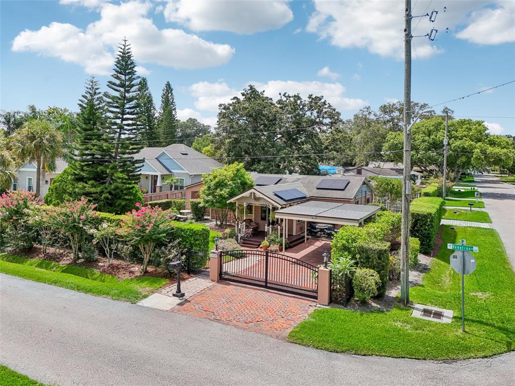 An aerial view of a single-story house with solar panels, a gated driveway, and landscaping — 1020 VENETIAN AVENUE, ORLANDO, FL