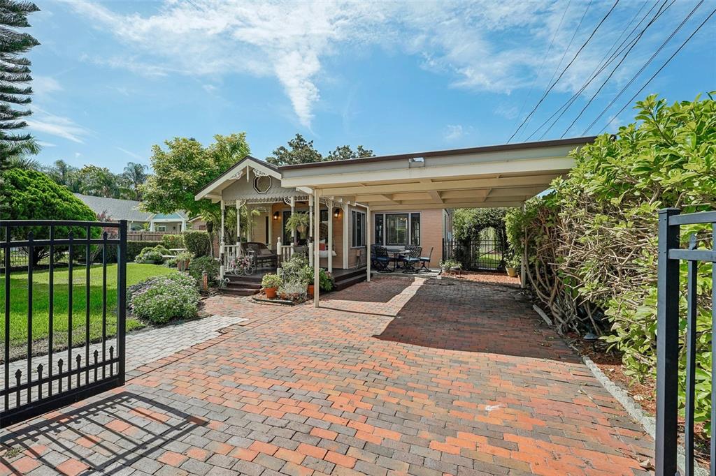 A house with a brick driveway, a covered carport, and a front porch with decorative trim — 1020 VENETIAN AVENUE, ORLANDO, FL